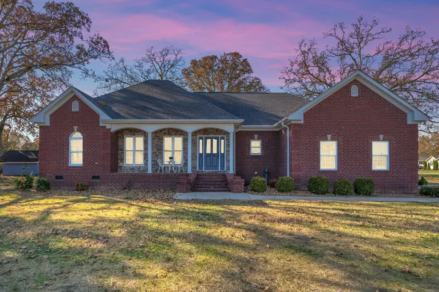 a view of a brick house with a yard