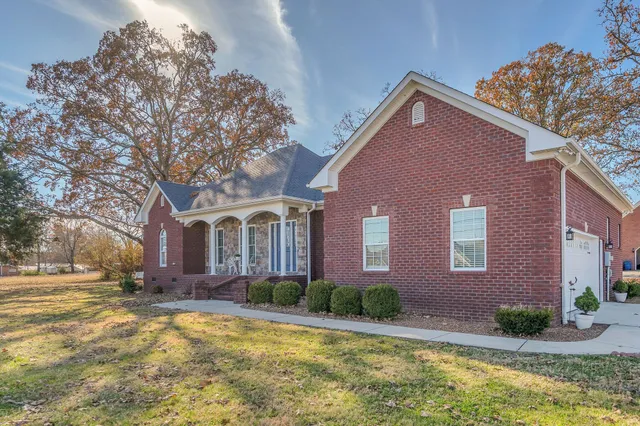 a front view of house with yard and trees around