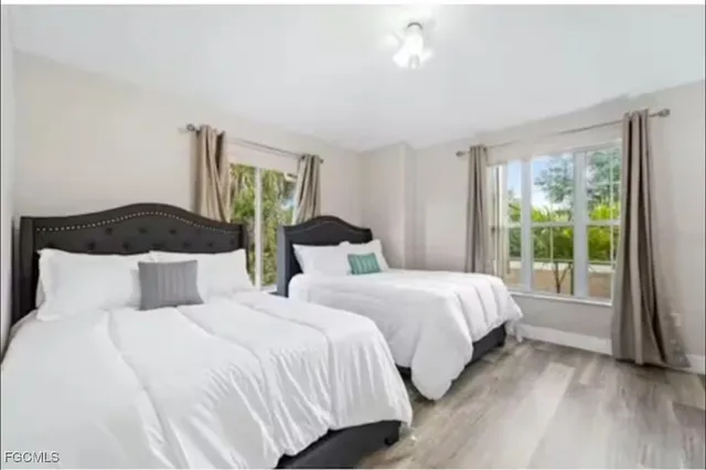 a bedroom with two beds and a large window