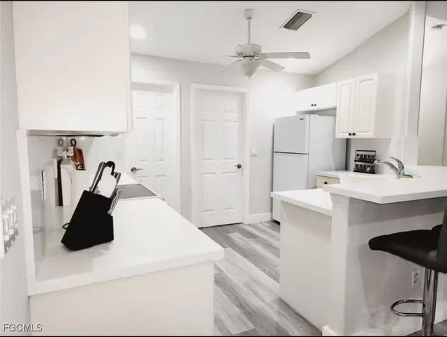 a close view of a sink and a refrigerator in a kitchen