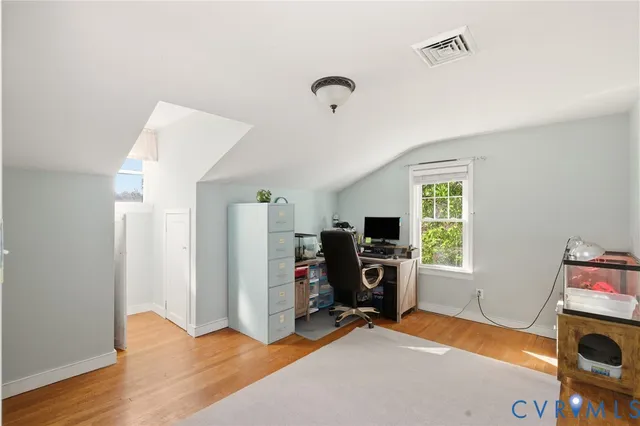 a view of a workspace with furniture and a window