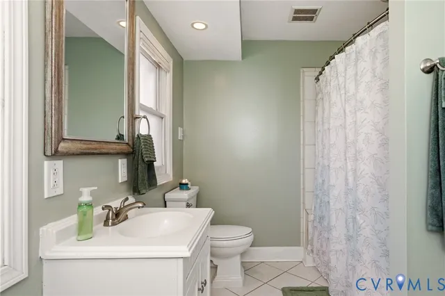 a bathroom with a sink a toilet and shower curtain