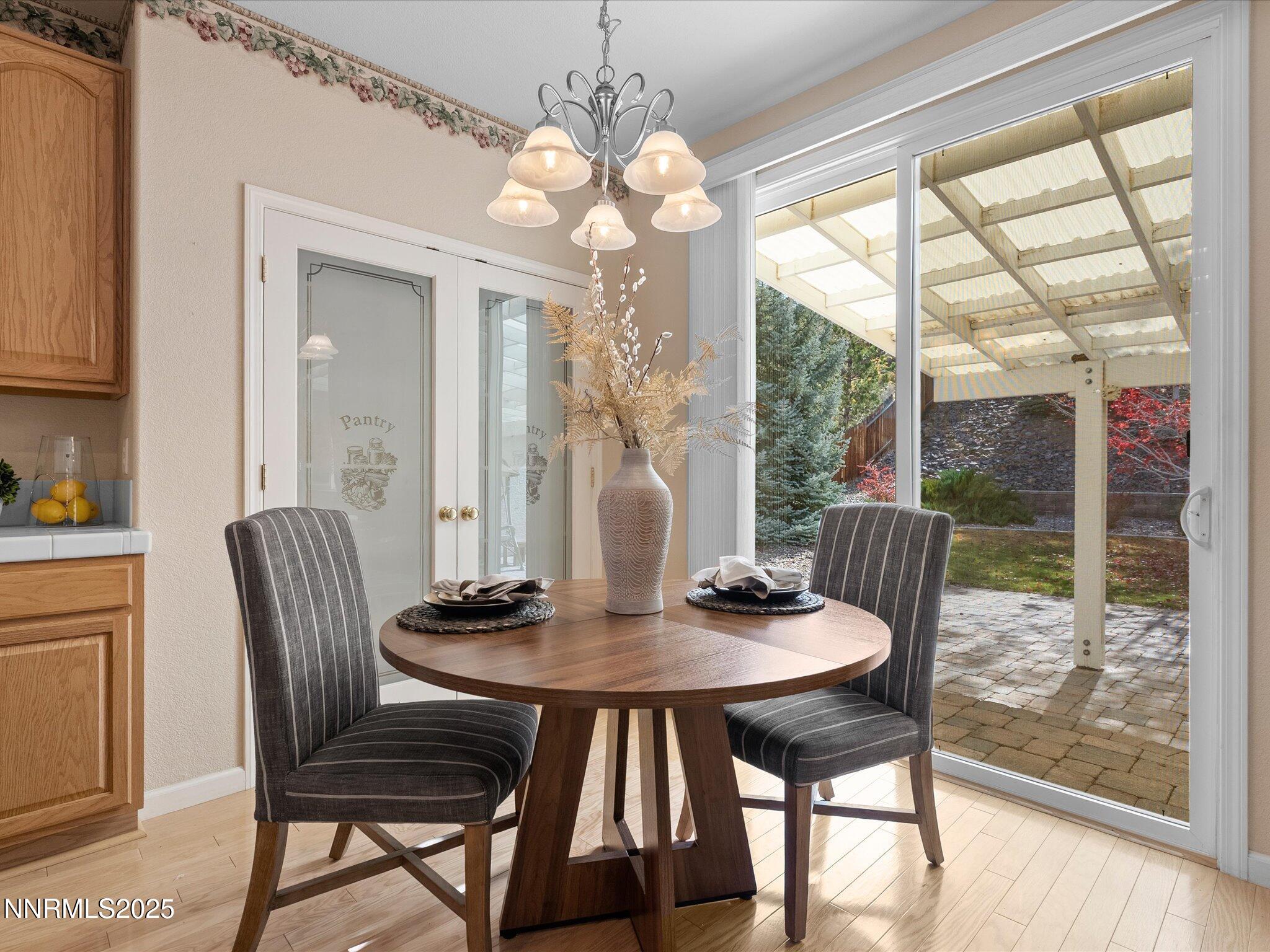 5952 Indus Drive Reno, NV 89502 - Photo 14 of 39 a dining room with furniture a chandelier and wooden floor