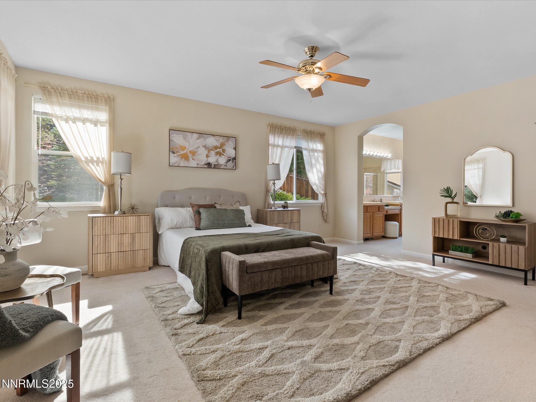 5952 Indus Drive Reno, NV 89502 - Photo 15 of 39 a spacious bedroom with a bed a couch and a chandelier