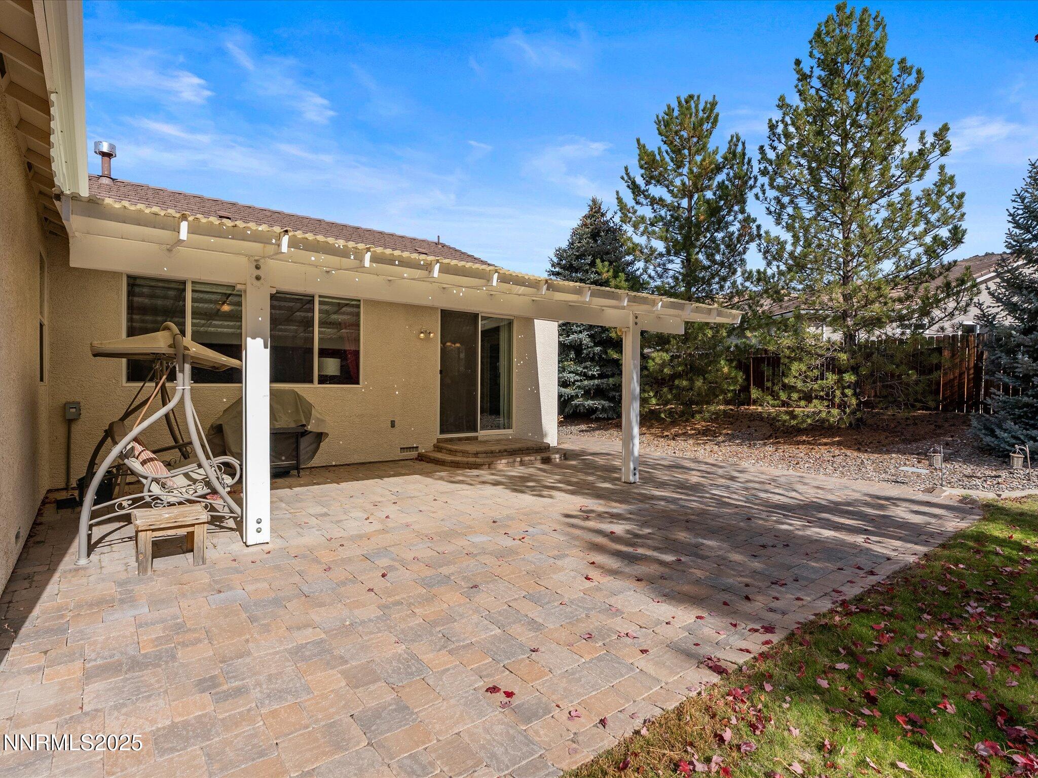 5952 Indus Drive Reno, NV 89502 - Photo 26 of 39 a view of a patio with table and chairs a barbeque with potted plants and floor to ceiling window