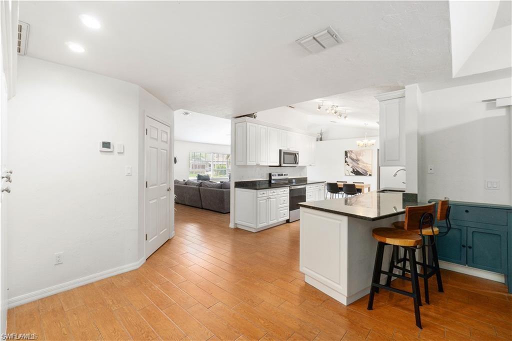 Undisclosed Address Naples, FL 34110 - Photo 7 of 19 a kitchen with a sink cabinets and wooden floor
