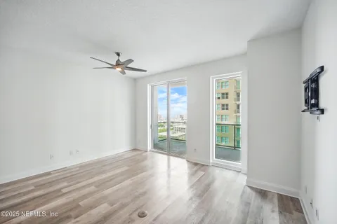 an empty room with wooden floor and windows