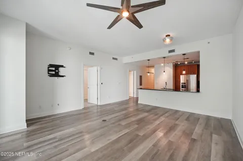 an empty room with windows and ceiling fan