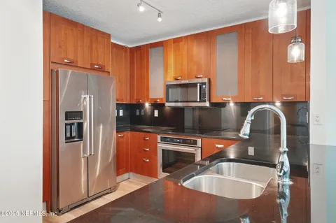 a kitchen with stainless steel appliances granite countertop a refrigerator stove and sink