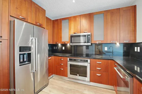 a kitchen with stainless steel appliances granite countertop a refrigerator microwave and sink