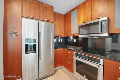 a kitchen with granite countertop a sink window and cabinets