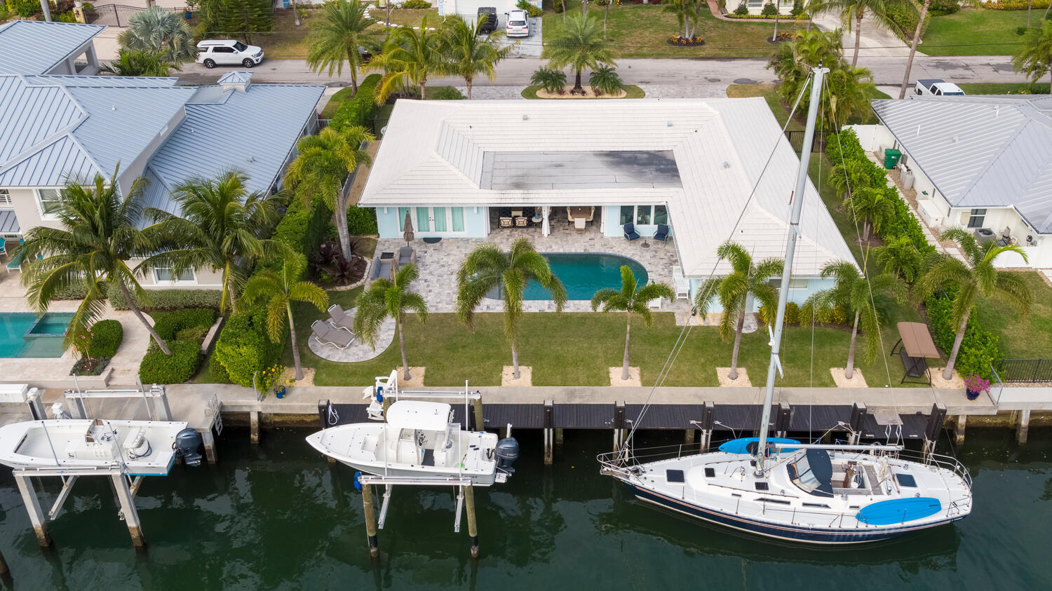 1041 Gulfstream Way Riviera Beach, FL 33404 - Photo 16 of 39 a view of a patio with table and chairs potted plants and large tree