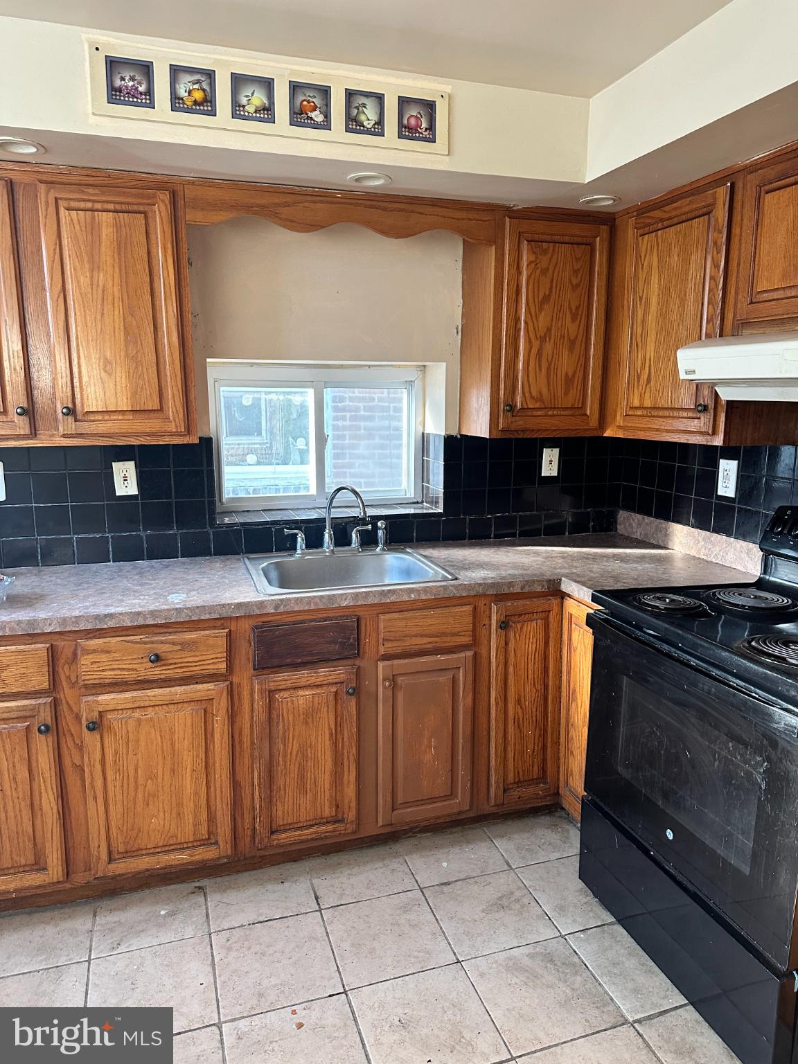 1508 West Nedro Avenue Philadelphia, PA 19141 - Photo 4 of 20 a kitchen with granite countertop a sink a stove a microwave and cabinets