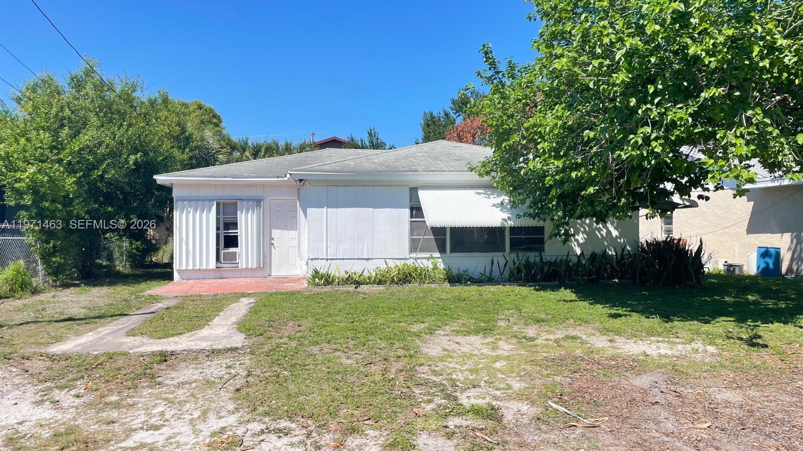 2908 Dunbar Street Fort Pierce, FL 34947 - Photo 10 of 10 a front view of a house with a yard and trees