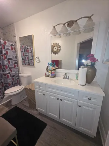 a bathroom with a double vanity sink toilet and a mirror