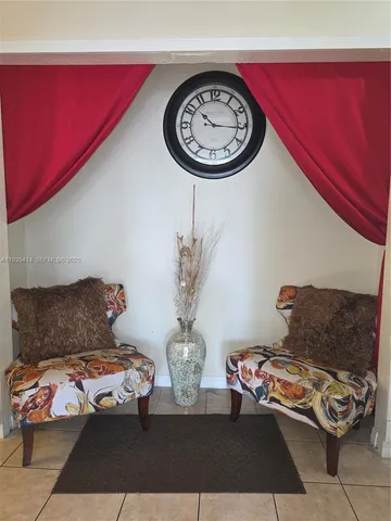 a living room with furniture a clock and a rug