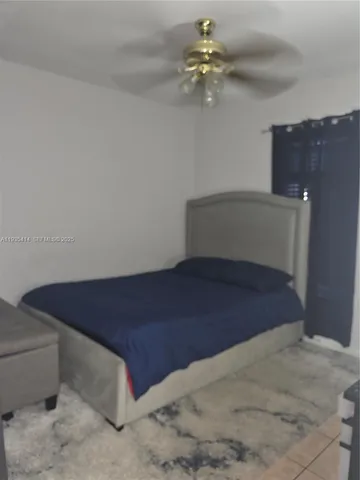 a room with a bed and a ceiling fan