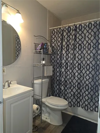 a bathroom with a toilet and a shower curtain