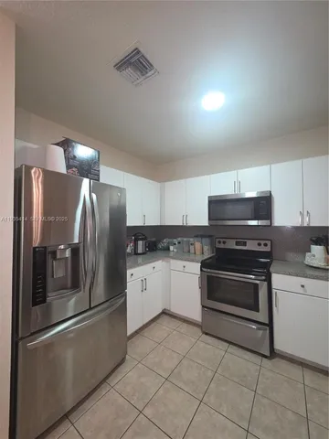 a kitchen with stainless steel appliances and a refrigerator