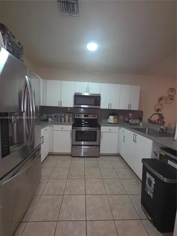 a kitchen with a stove sink and cabinets