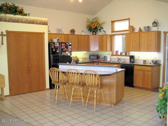 8810 Robillard Road Moxee, WA 98936 - Photo 8 of 29 a kitchen with stainless steel appliances granite countertop a sink a stove a dining table and chairs