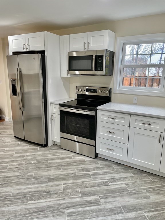 7 Center Road Shirley, MA 01464 - Photo 11 of 28 a kitchen with stainless steel appliances granite countertop a stove a microwave and a refrigerator