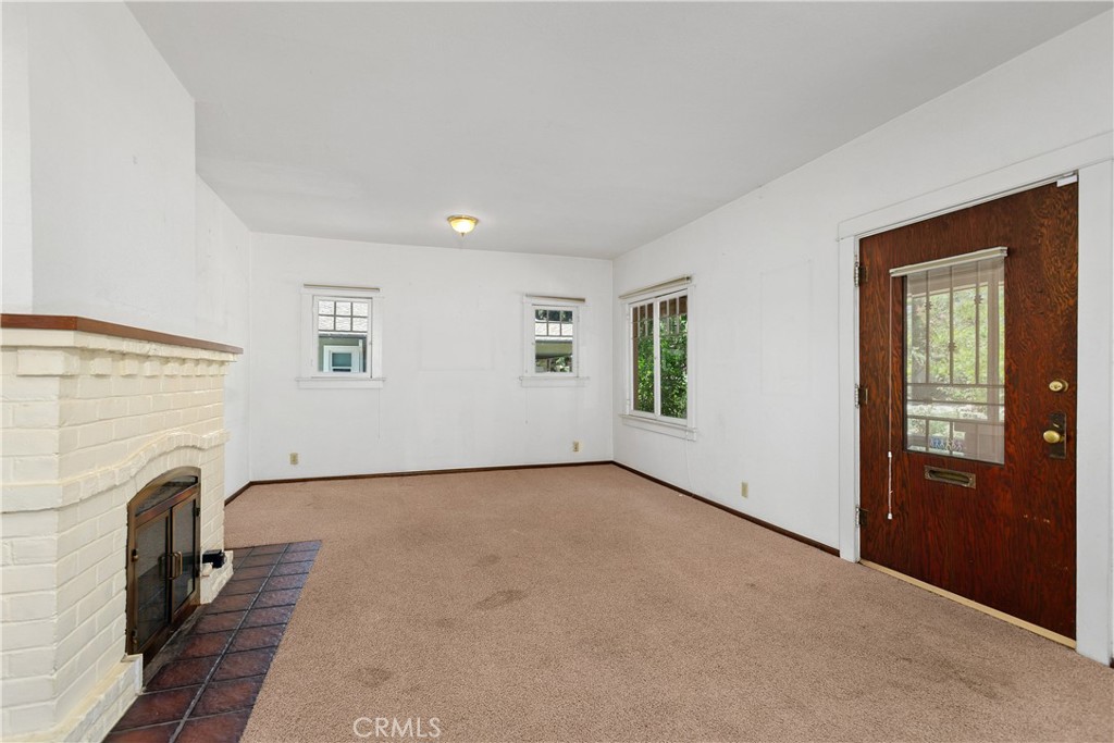 3892 Oakwood Place Riverside, CA 92506 - Photo 4 of 36 Inviting living room featuring a classic craftsman fireplace and beautiful solid wood, windowed front door.