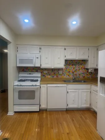 a kitchen with granite countertop a stove a sink and a refrigerator