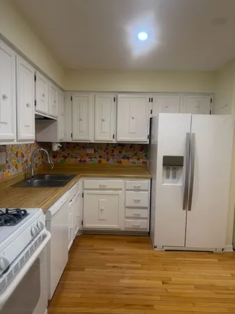a kitchen with granite countertop white cabinets and white appliances