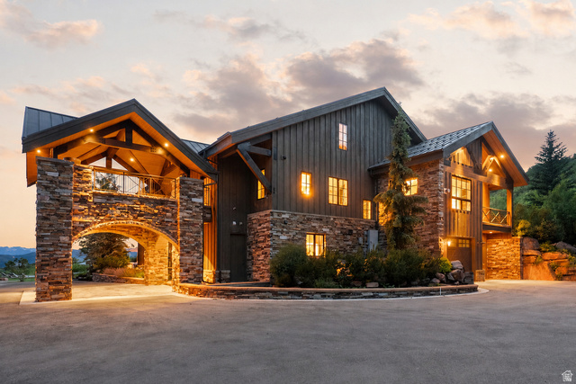 5971 Maple Ridge Trail Oakley, UT 84055 - Photo 38 of 43 Stone and wood-sided architectural residence featuring a porte-cochere with an upper balcony, exposed timber beams, and a metal roof