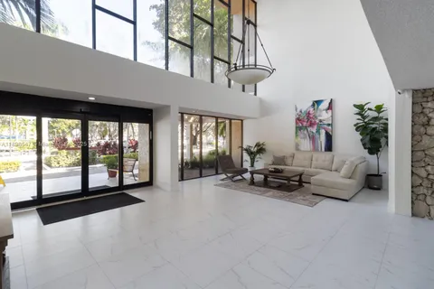 a living room with furniture and large windows