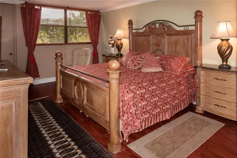 a bed room with a bed dresser and a two mirror