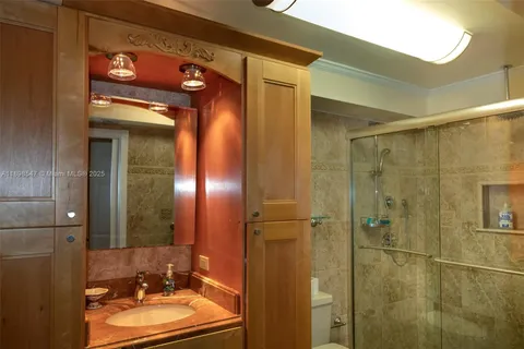 a bathroom with a sink vanity granite shower and a mirror