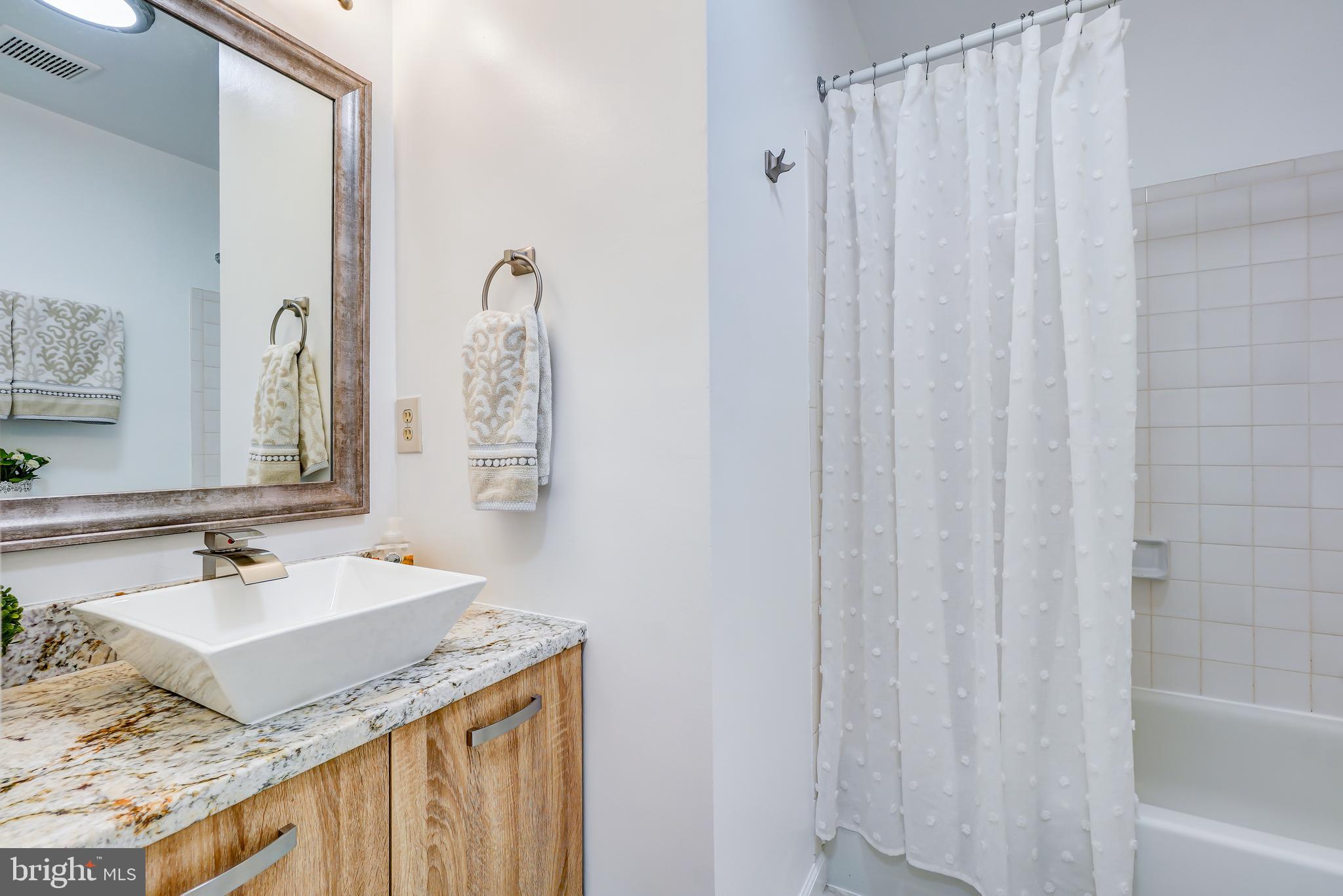 614 Suffield Drive Gaithersburg, MD 20878 - Photo 14 of 22 a bathroom with a granite countertop sink and a mirror