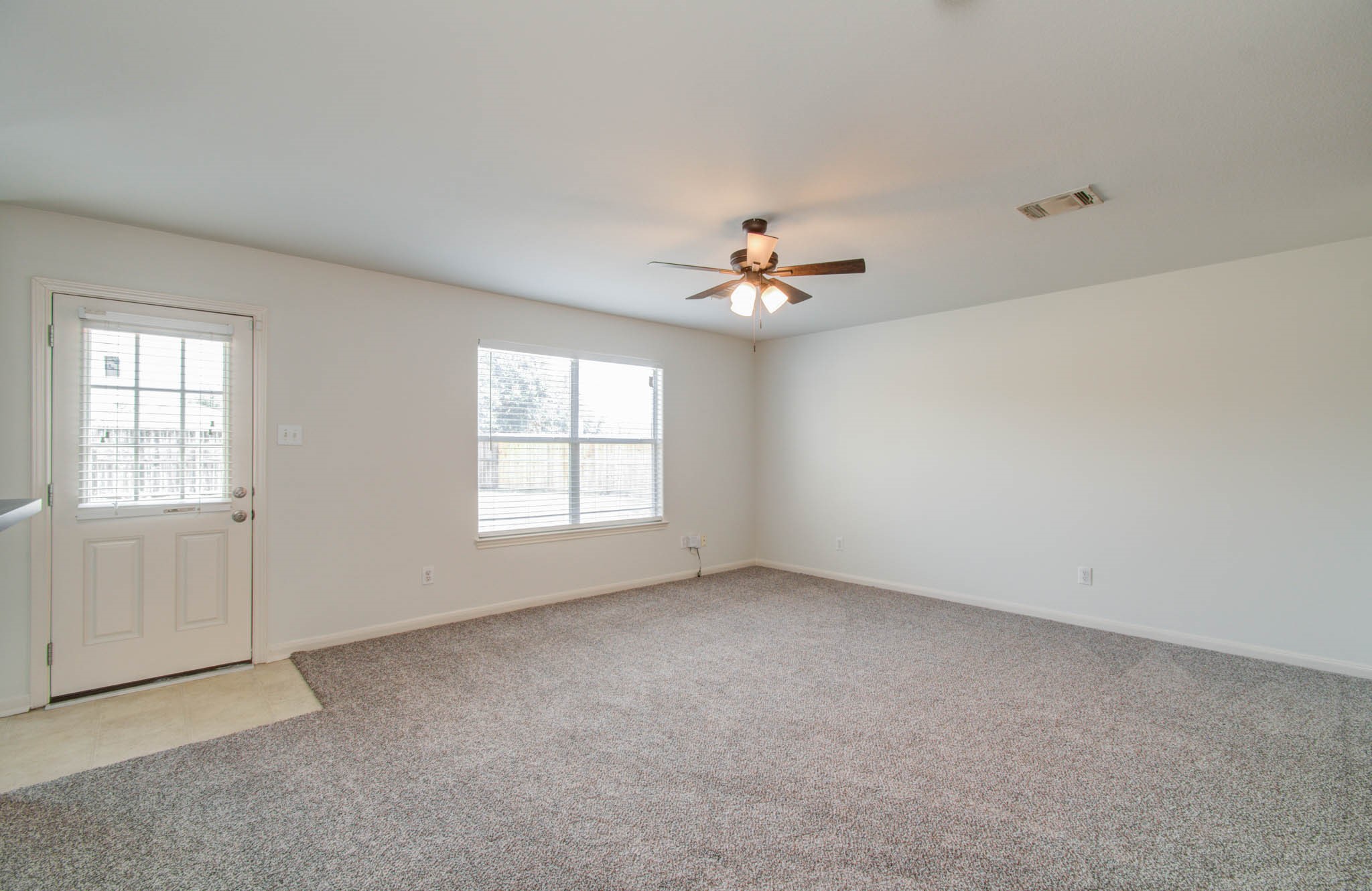 4239 Nueces River Loop Spring, TX 77386 - Photo 15 of 50 an empty room with windows and chandelier fan