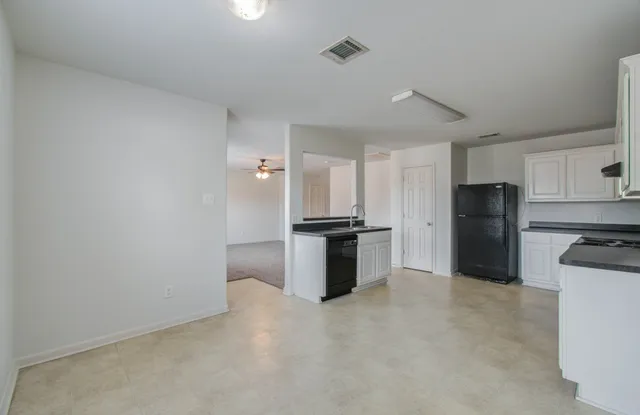 a kitchen with granite countertop a refrigerator and a stove