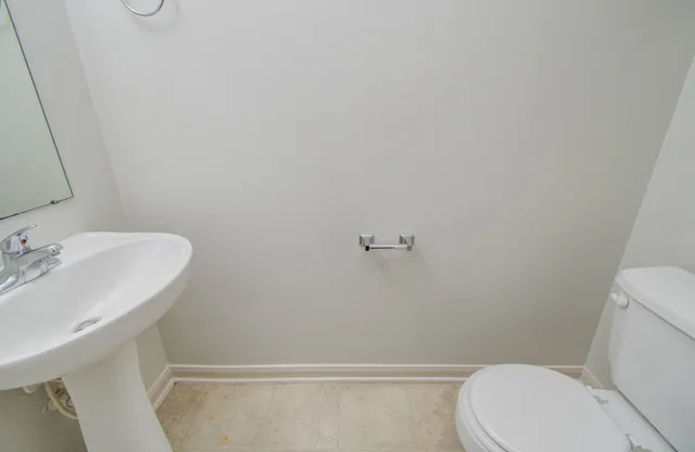 a white toilet sitting next to a bathroom sink