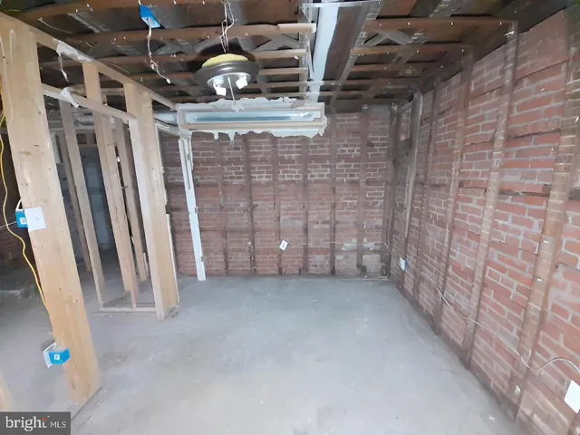 a view of an empty room with wooden floor and stairs