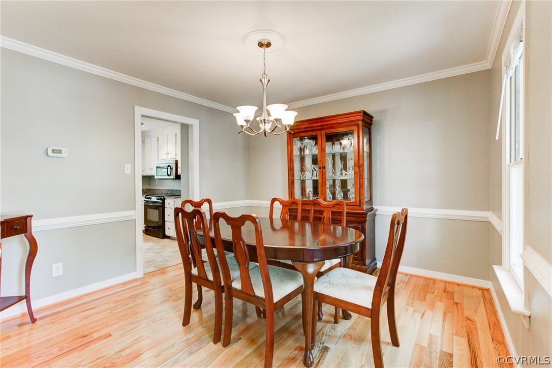 703 Fennimore Road Midlothian, VA 23114 - Photo 4 of 22 a dining room with furniture a chandelier and wooden floor