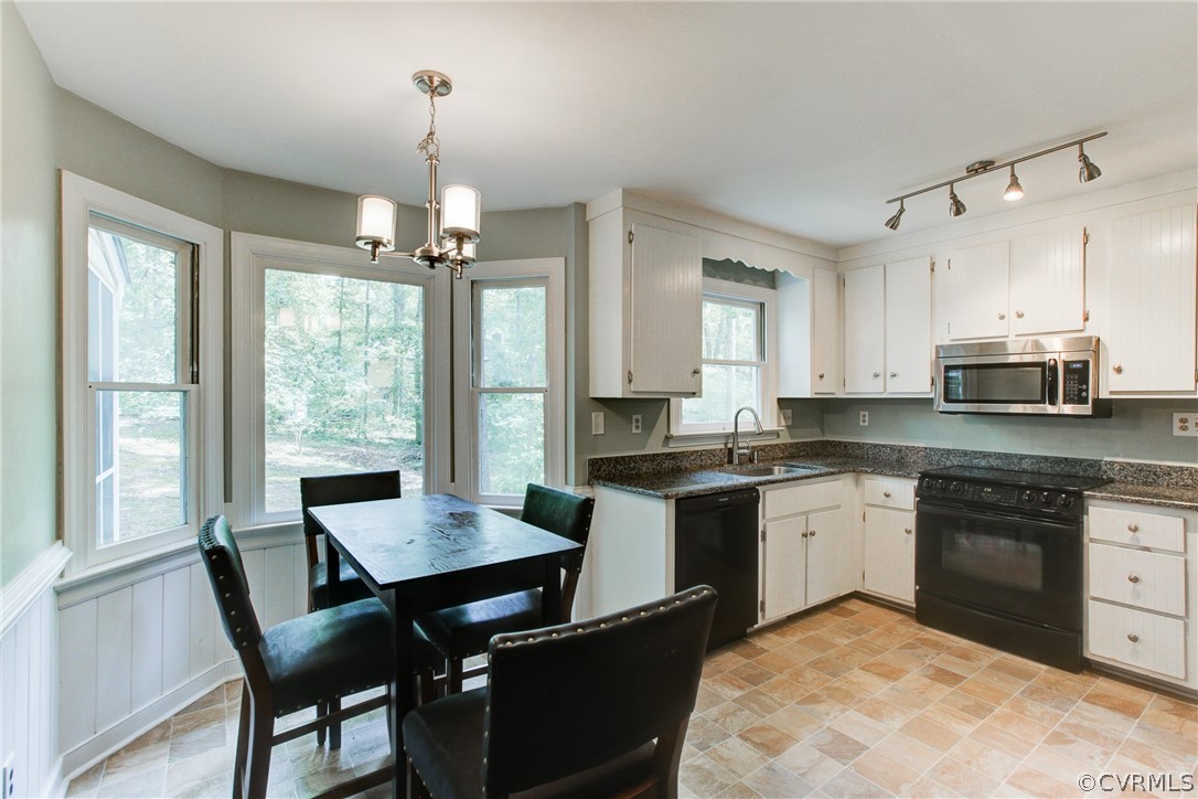 703 Fennimore Road Midlothian, VA 23114 - Photo 9 of 22 a kitchen with a stove a sink dishwasher a dining table and chairs with wooden floor