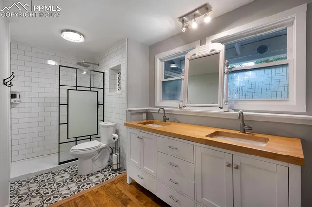a bathroom with a double vanity sink mirror and toilet