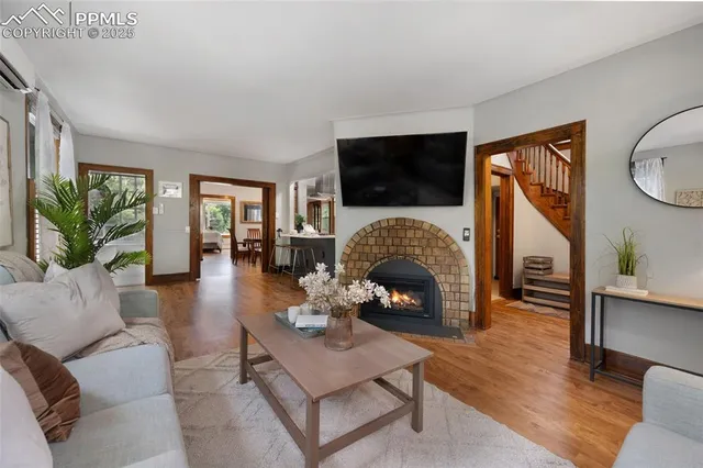 a living room with furniture a fireplace a flat screen tv and a large window