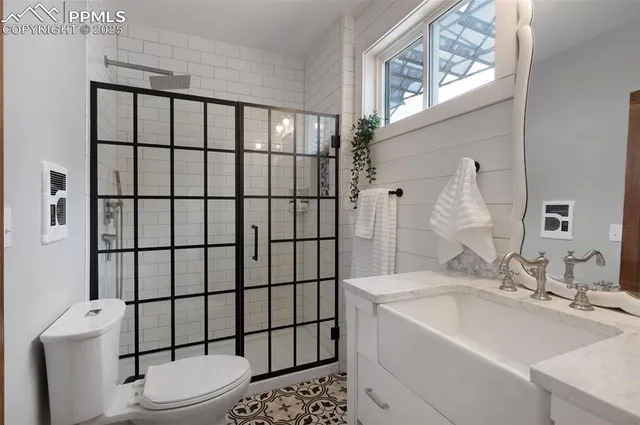 a bathroom with a sink a toilet and shower