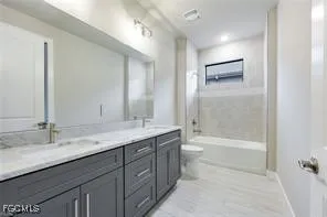 a bathroom with a granite countertop sink a toilet and shower