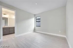 an empty room with windows and cabinet