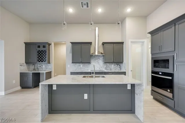 a large kitchen with kitchen island granite countertop a large counter top stainless steel appliances and cabinets