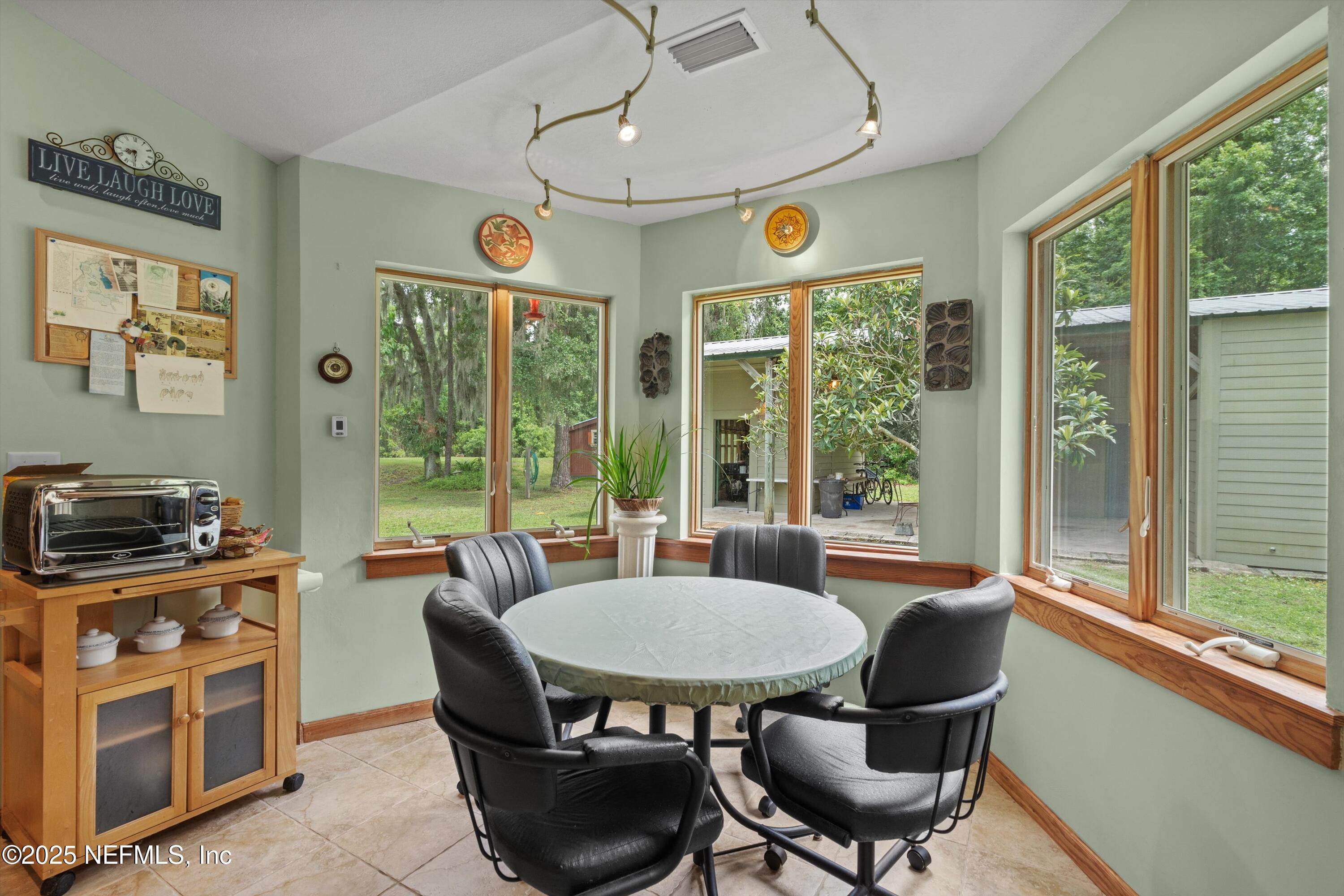 7720 Riverdale Road St. Augustine, FL 32092 - Photo 22 of 60 a view of a dining room with furniture large windows and wooden floor