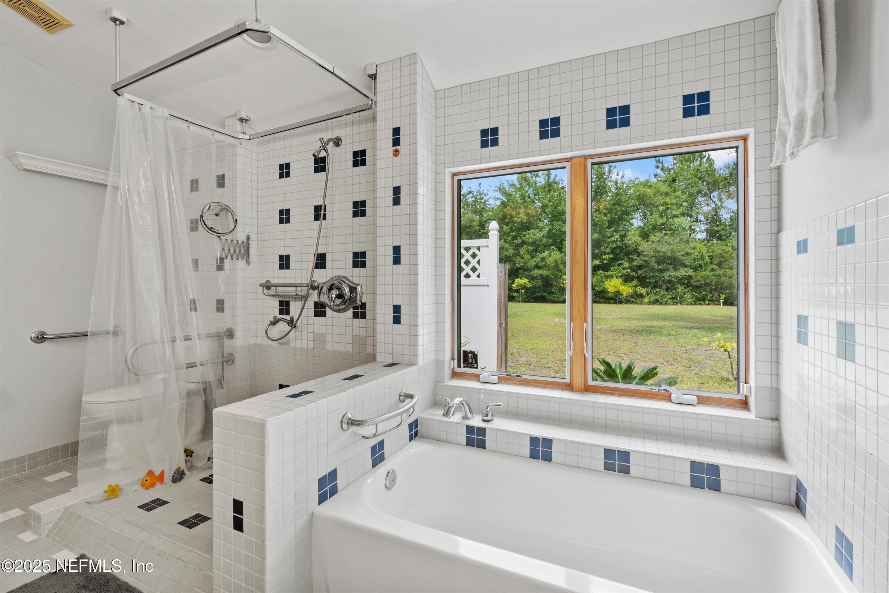 7720 Riverdale Road St. Augustine, FL 32092 - Photo 29 of 60 a bathroom with bathtub a shower and a window
