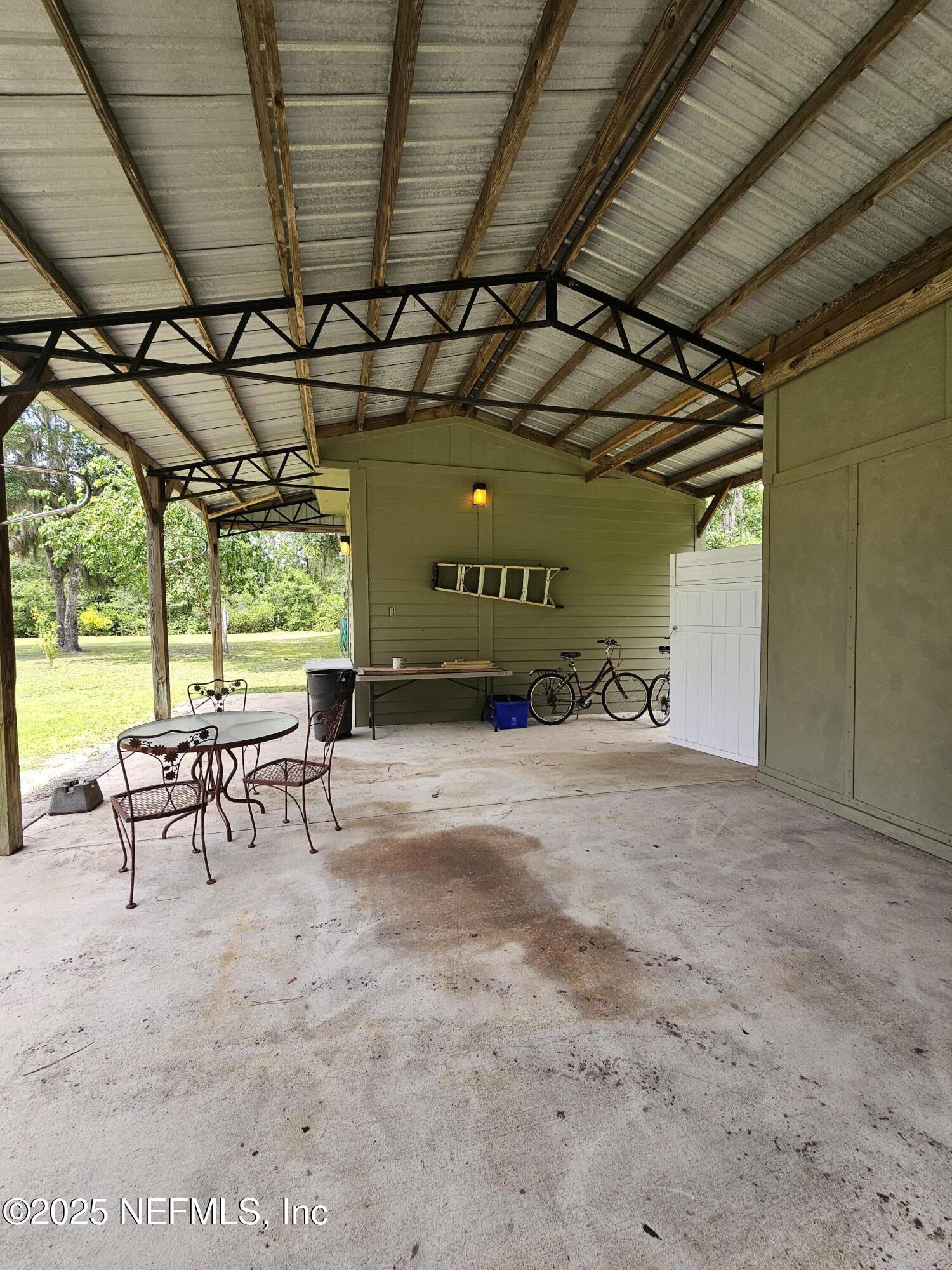7720 Riverdale Road St. Augustine, FL 32092 - Photo 34 of 60 a view of a porch with furniture and a backyard