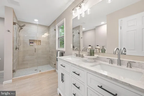 a bathroom with a shower tub double vanity and a mirror